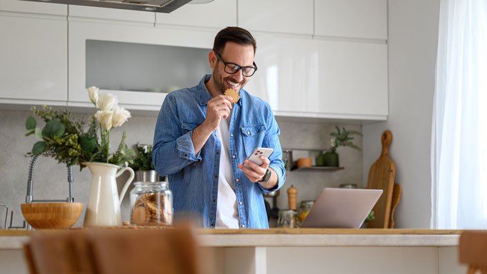 guy in kitchen eating snack