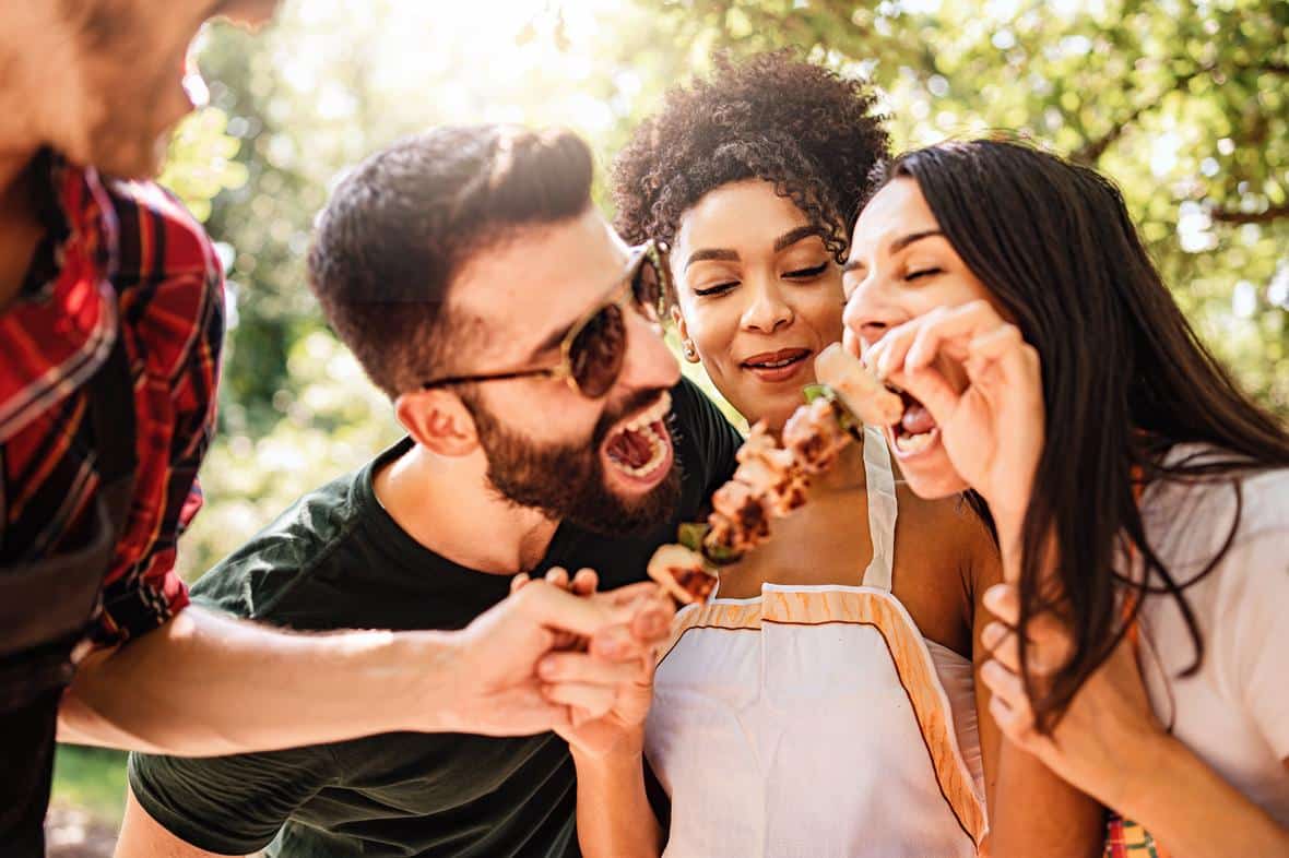 Friendly people looking at meat skewer