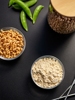 Three different grain products in glass jars on a black table