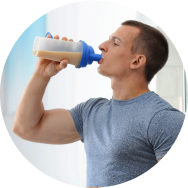 A fit man drinking a protein shake from a bottle.