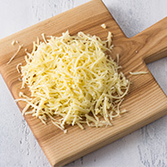 C25 Shredded cheese on cutting board
