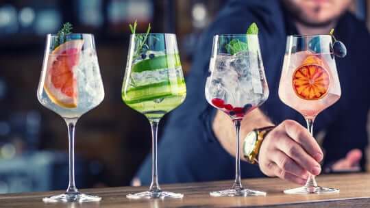 bartender lining up cocktails on bar